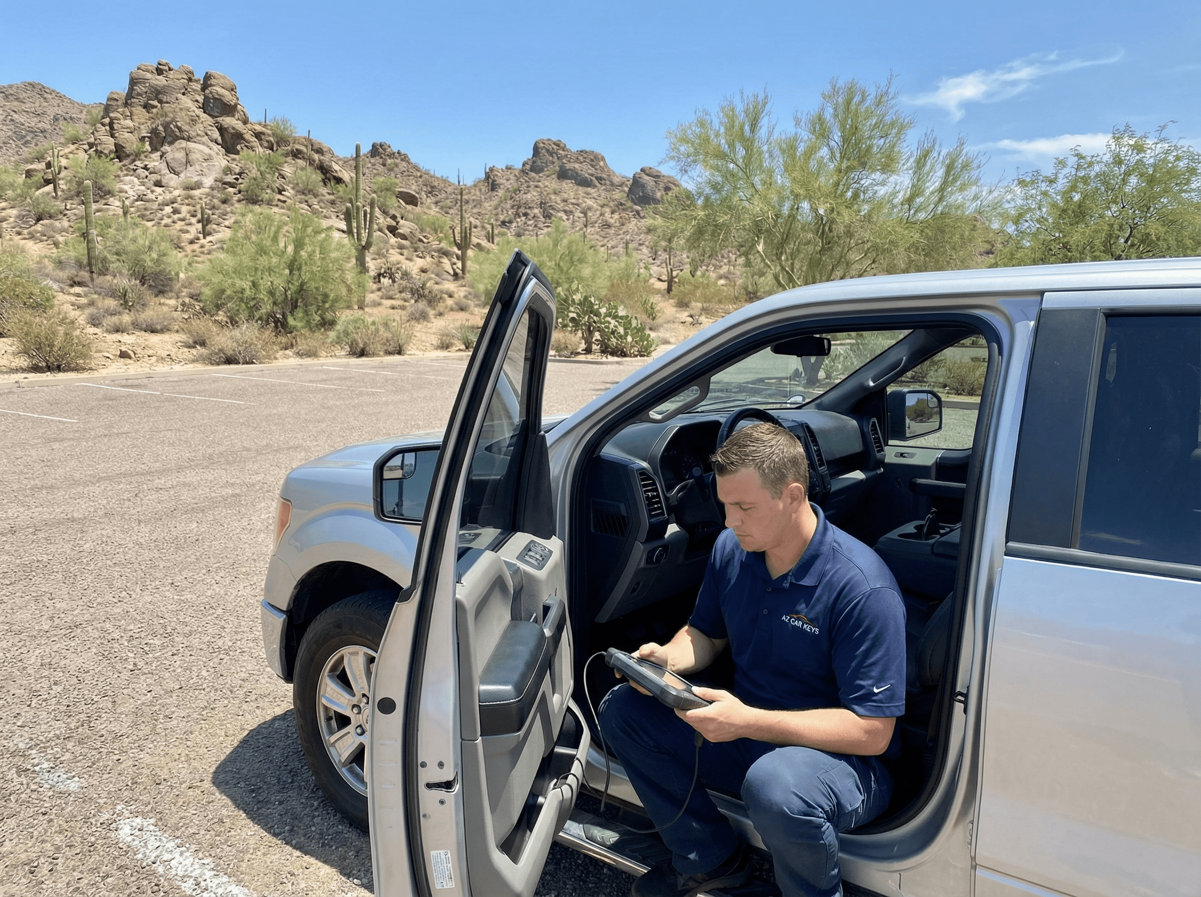 AZ Car Keys car key technician programming a car key in Cave Creek, Arizona with rocky desert landscape in background